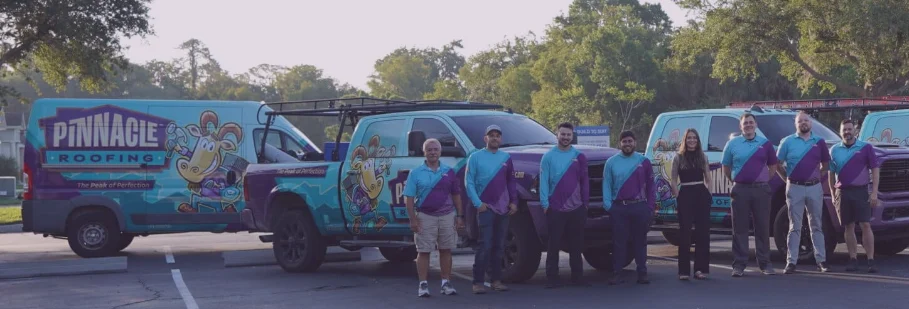 Pinnacle Roofing Group crew in front of the wrapped trucks